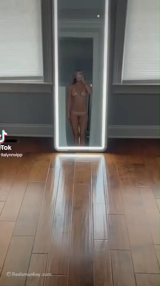 This tan lined sexy model makes nude walk to her long mirror