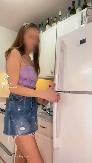 Cute chick was collecting clothes from her refrigerator